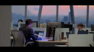 Persona trabajando en oficina con el atardecer de fondo.